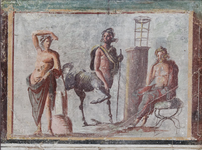 Apolo à esquerda, o centauro Quíron ao centro e Asclépio sentado à direita, com o bastão apoiado no ombro. Afresco romano em parede pintada. Museo Archeologico Nazionale, Nápoles (inv. 8846).