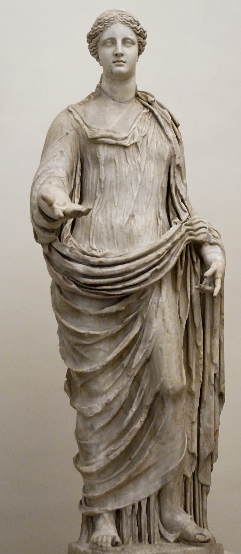 Deméter de pé, de peplo e manto, a mão direita aberta à frente. Mármore de grão grosso, obra romana; a cabeça é restauração moderna. Museo Nazionale Romano — Palazzo Altemps, Roma (inv. 8546).