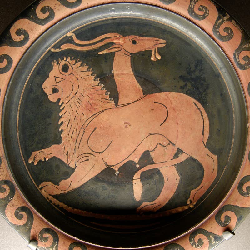 A Quimera de perfil: corpo e cabeça de leão, a juba em espinhos, uma cabeça de cabra saindo do meio do lombo e a serpente que lhe serve de cauda erguida atrás. Prato apuliano de figuras vermelhas, ca. 350–340 a.C. Museu do Louvre, Paris (K 362).
