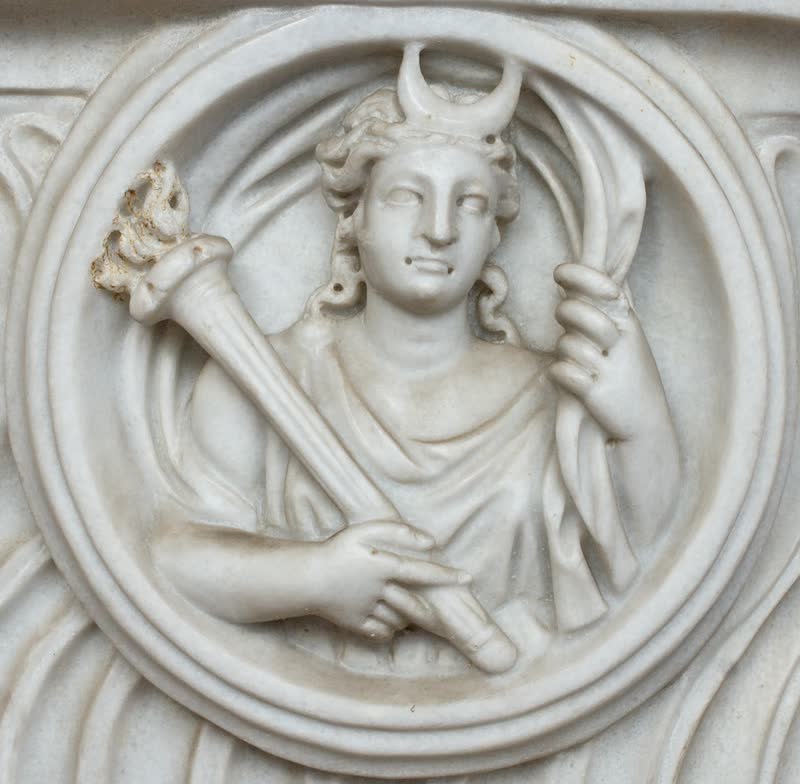Busto de Selene com o crescente da lua sobre a cabeça, tocha na mão e o véu inflado em arco às costas, dentro de um clípeo. Detalhe de um sarcófago romano de estrigilos, em mármore. Museo Nazionale Romano — Termas de Diocleciano, Roma.
