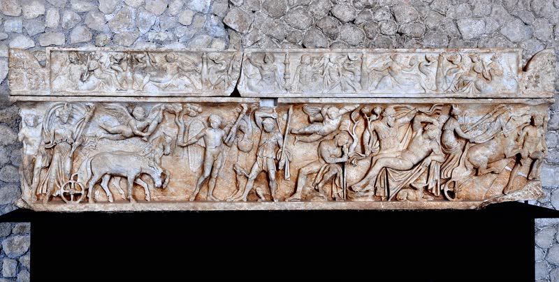 Selene desce da biga, à esquerda, e atravessa o relevo até Endimião adormecido, à direita, cercada de erotes e figuras da caçada. Frente de sarcófago romano em mármore, ca. 140–160 d.C. Museu Arqueológico de Palestrina, Itália.